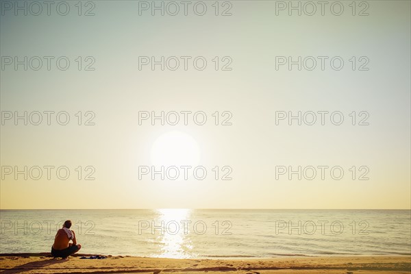 Mixed race man sitting on beach