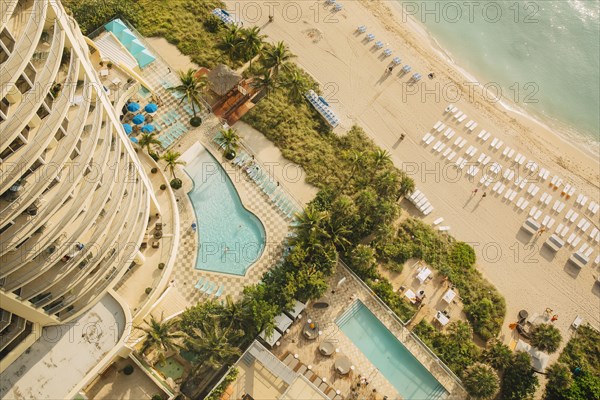 Aerial view of hotel pools and tropical beach