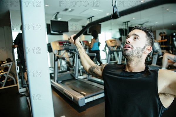 Man using exercise machine in gymnasium