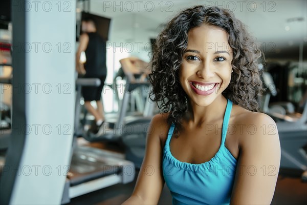 Woman using exercise machine in gymnasium