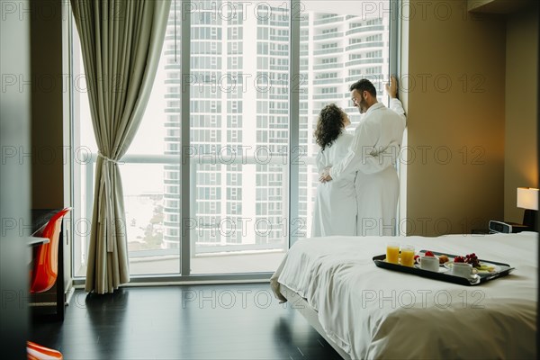 Couple hugging in bathrobes in hotel room