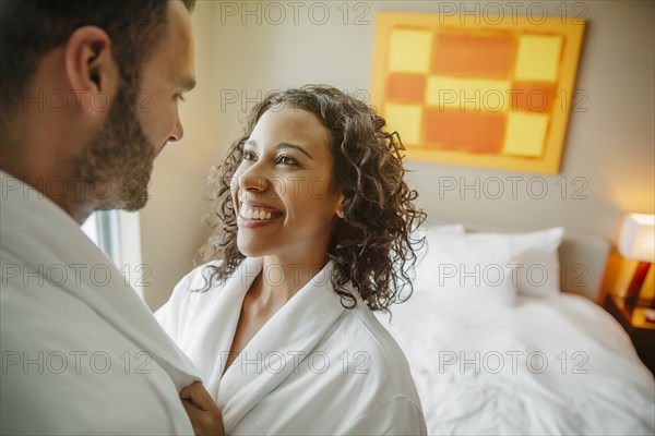 Couple hugging in bathrobes in hotel room