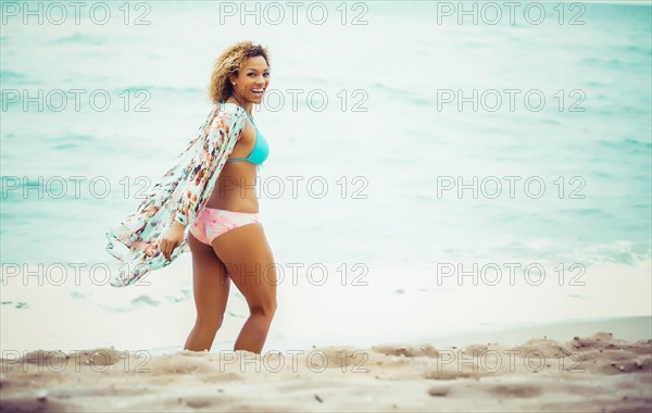 Mixed race teenager wearing bikini on beach