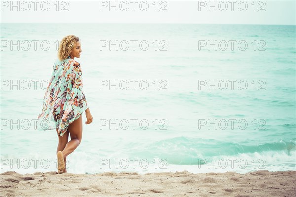 Mixed race teenager wearing cover-up on beach