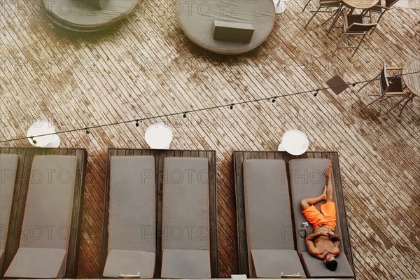 Aerial view of man laying on deck chair