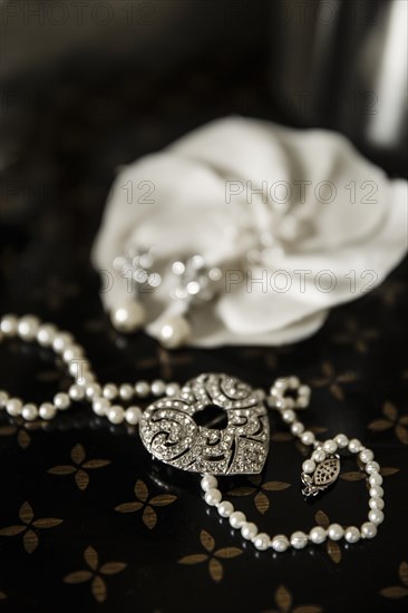 Close up of pearl and heart necklace on table