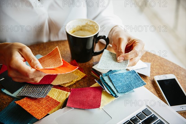 Mixed race designer examining fabric swatches