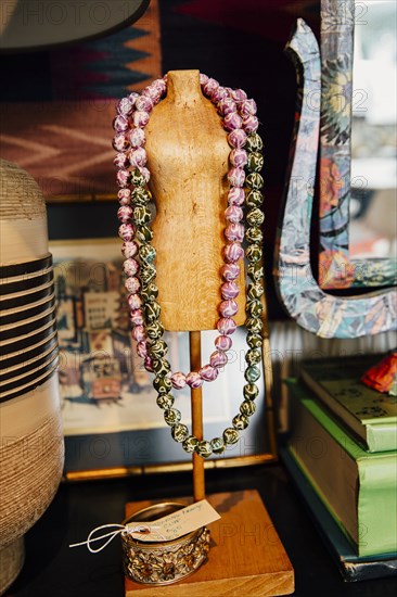 Necklaces draped over mannequin stand