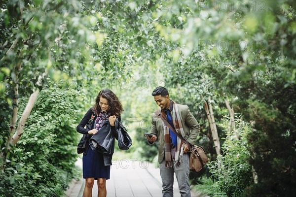 Couple walking on wooden walkway in park