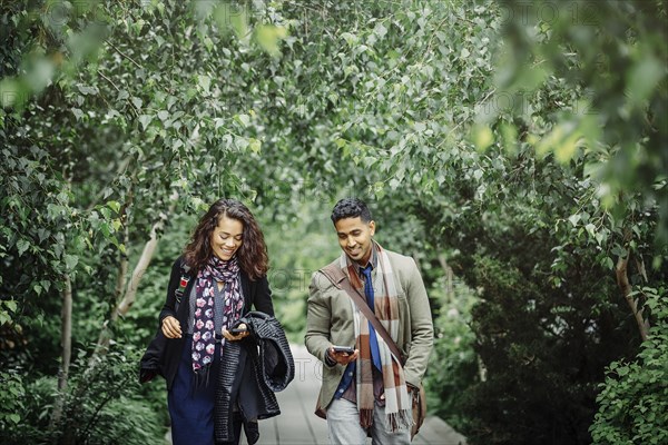 Couple walking on wooden walkway in park