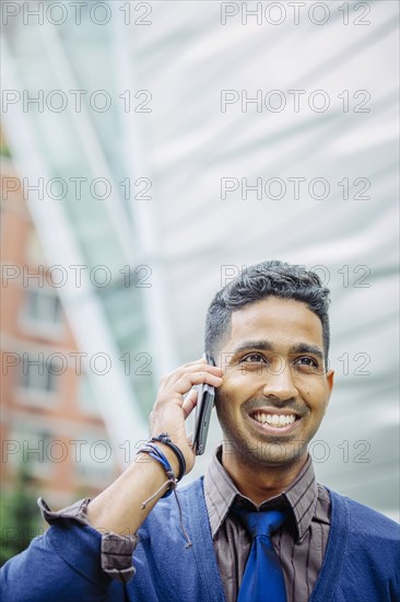 Indian businessman talking on cell phone outdoors