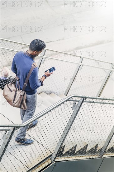 Indian businesswoman using cell phone on steps