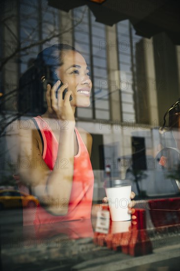 Mixed race woman talking on cell phone in cafe