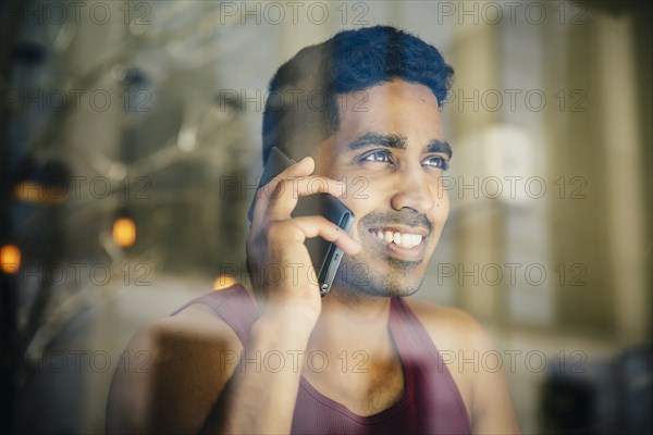 Indian man talking on cell phone in cafe