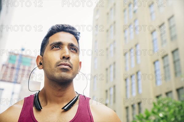 Indian athlete listening to earbuds in city