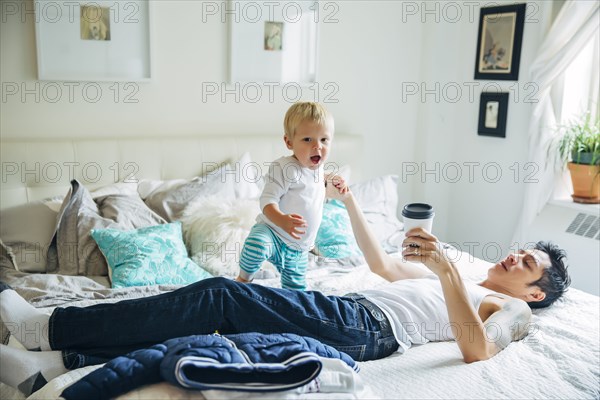 Father and son playing on bed