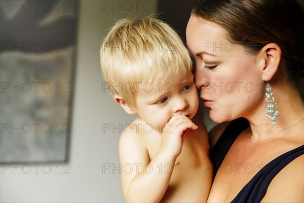 Close up of mother holding son in living room
