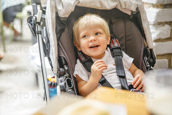 Mixed race boy sitting in stroller chair