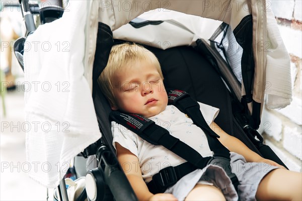 Mixed race boy sleeping in stroller