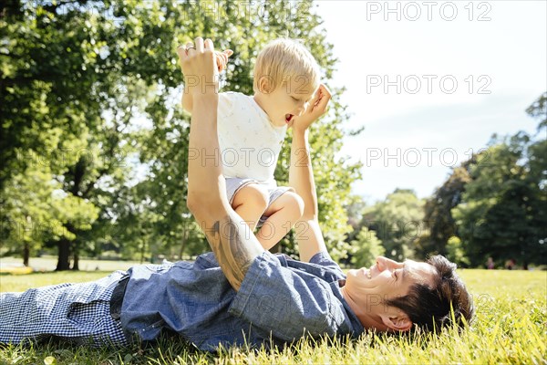 Father and son playing in grass in park