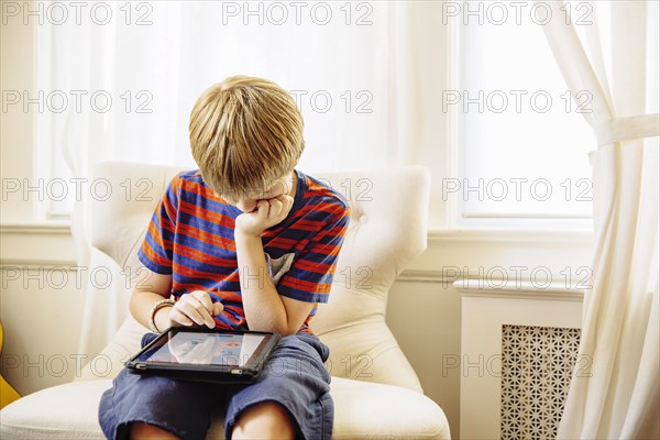 Caucasian boy using digital tablet in living room