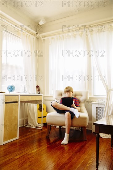 Caucasian boy using digital tablet in living room