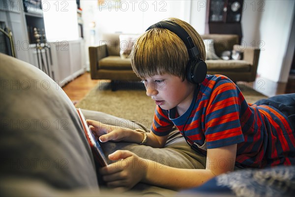 Caucasian boy using digital tablet on sofa