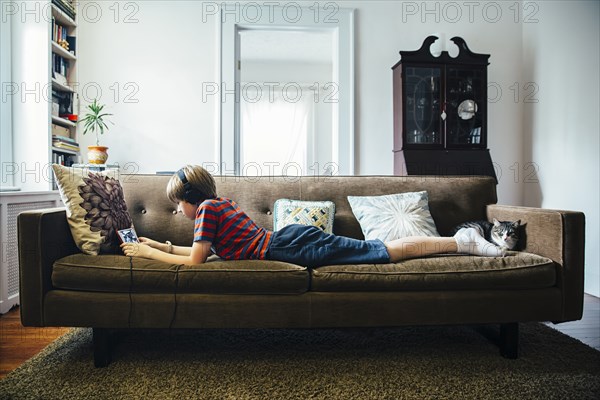 Caucasian boy using digital tablet on sofa