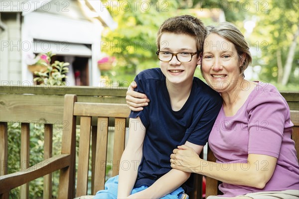 Caucasian grandmother and grandson smiling in backyard