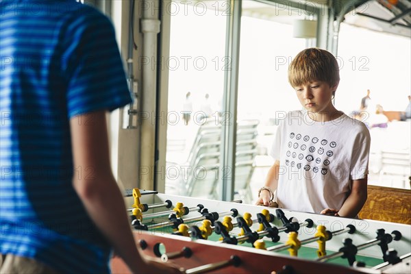 Caucasian brothers playing foosball