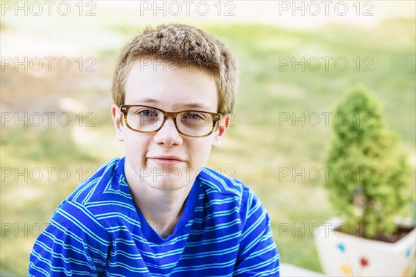 Caucasian teenage boy smiling in backyard