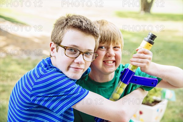 Caucasian brothers hugging in backyard