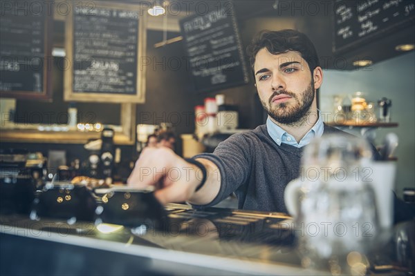 Caucasian barista making coffee in cafe