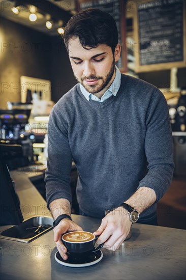 Caucasian barista making coffee in cafe