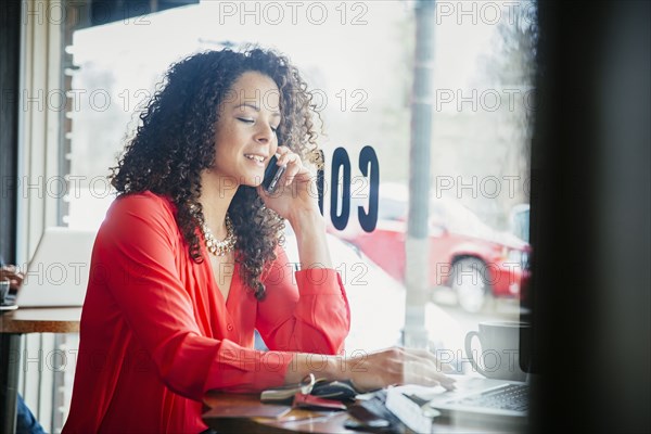 Businesswoman talking on cell phone in cafe