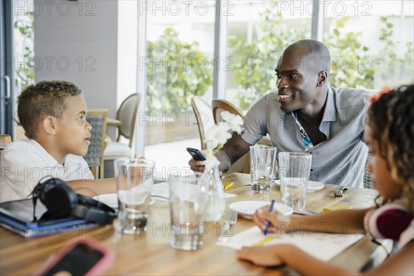 Father and children eating in restaurant