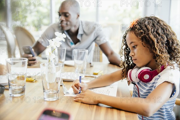 Girl coloring at restaurant table