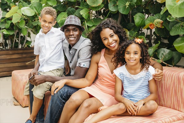 Family smiling on sofa in garden