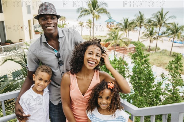 Family smiling on steps overlooking beach