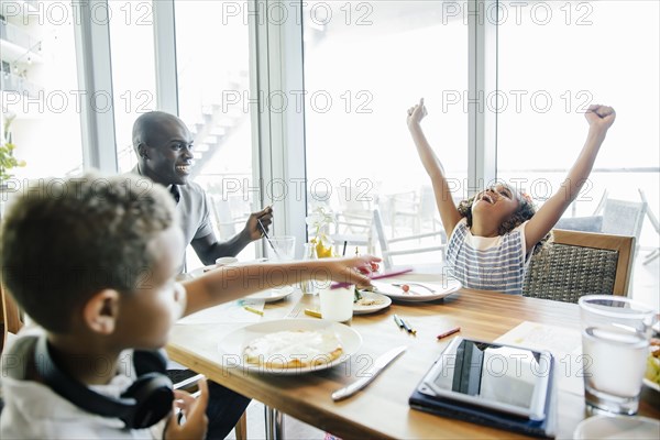 Girl cheering at table in restaurant