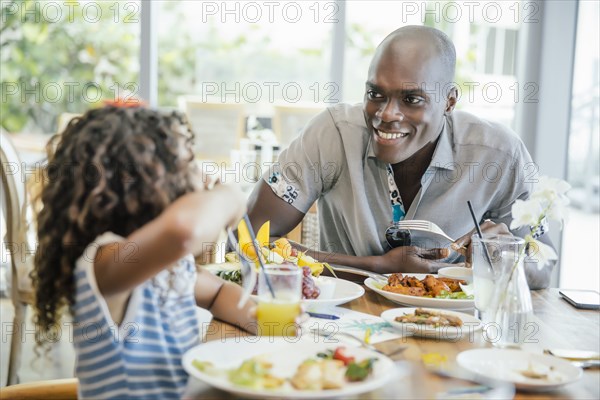 Father and daughter eating at restaurant