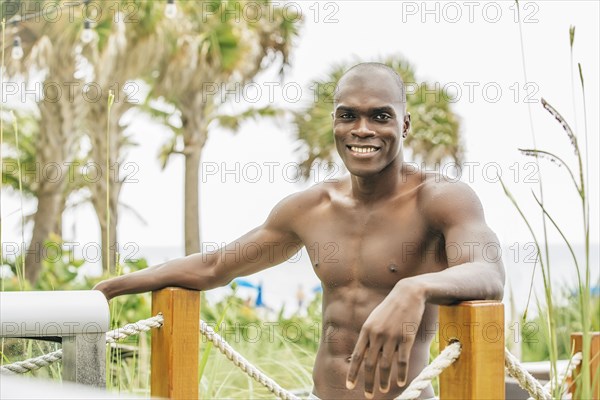 Black man standing on beach walkway