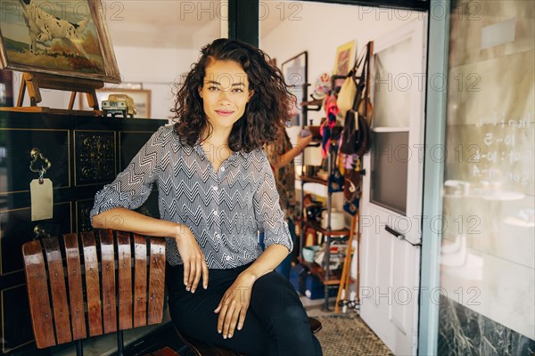 Mixed race entrepreneur sitting outside store