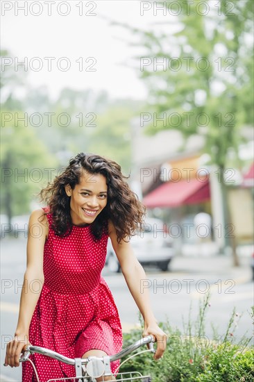 Mixed race woman riding bicycle in city