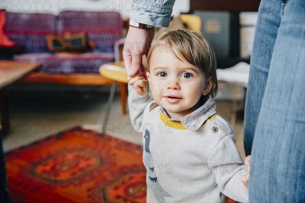 Caucasian mother helping baby son walk