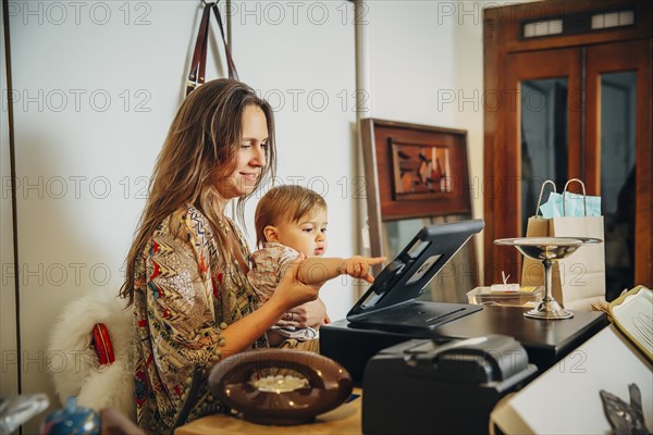 Caucasian entrepreneur and son playing with register
