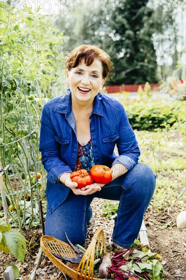 Caucasian woman holding tomatoes in garden