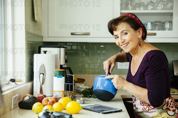 Caucasian woman cooking in kitchen