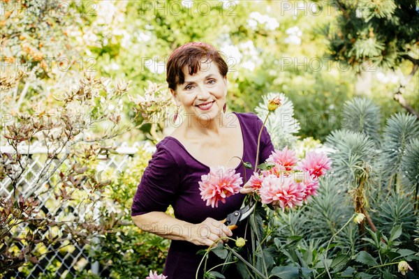 Caucasian woman picking flowers in garden