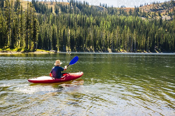 Caucasian man rowing canoe on remote lake